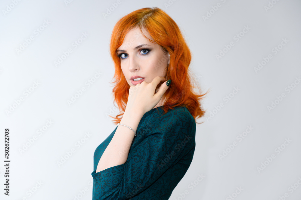 Portrait of a red-haired pretty girl with excellent makeup and bright curly hair on a white background. Beauty concept, sample of beautiful hairstyle and makeup with cosmetics. Portrait of a red-haired pretty girl with excellent makeup and bright curly hair on a white background. Beauty concept, sample of beautiful hairstyle and makeup with cosmetics.