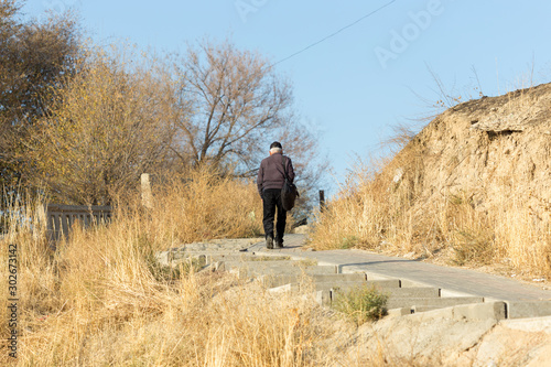 a gray-haired old man climbs the stairs. Senior healthy lifestyle. © donikz