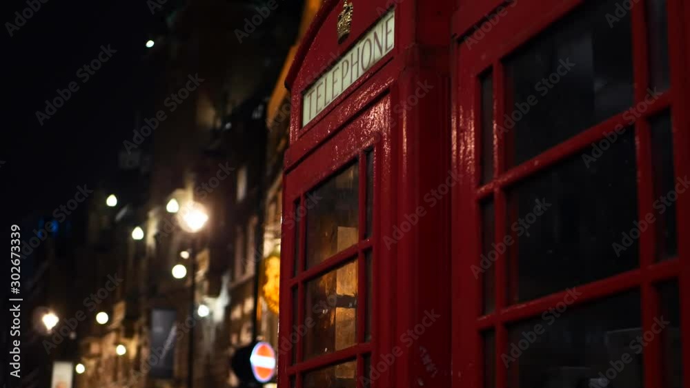 Red phone box at christmas night in London at a traditional pub 4K Red phone box at christmas night in London at a traditional pub 4K