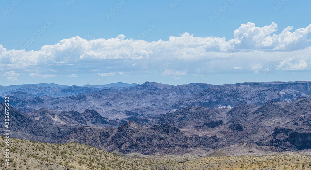 Arid landscape of Arizona. The crumbling sandstone mountains and blue sky	