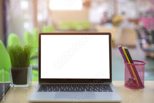 Computer laptop with white blank screen isolated  on work table in office.