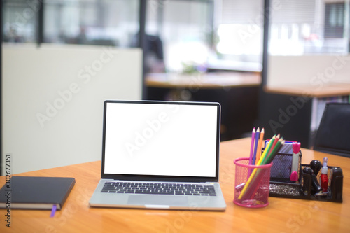 Computer laptop with white blank screen isolated  on work table in office.