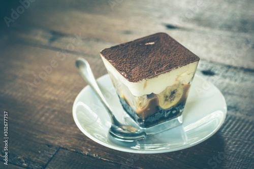 Close up view of Banoffee pie on the plate with wooden table. photo