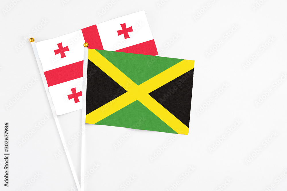 Jamaica and Georgia stick flags on white background. High quality fabric, miniature national flag. Peaceful global concept.White floor for copy space. Jamaica and Georgia stick flags on white background. High quality fabric, miniature national flag. Peaceful global concept.White floor for copy space.