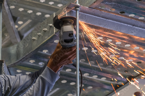 Professional technicians are cutting steel with sparks on the site.