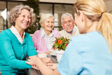 Pflegehilfe kümmert sich um Gruppe Senioren