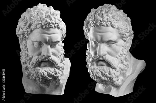 Two bust of Hercules. Heracles head sculpture, plaster copy of a statue isolated on black. Son of Zeus. Ancient statue of hero. photo