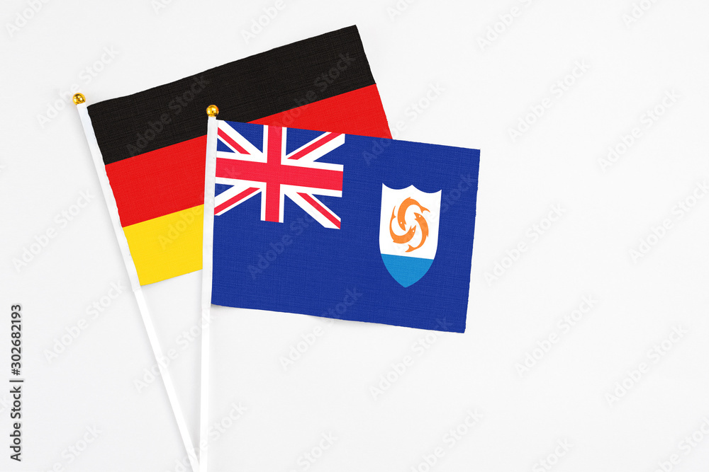 Fototapeta premium Anguilla and Germany stick flags on white background. High quality fabric, miniature national flag. Peaceful global concept.White floor for copy space.