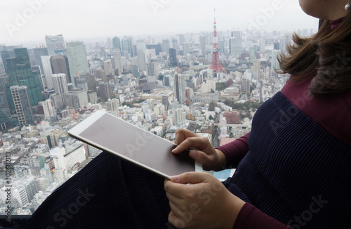 Photography business woman using tablet over view of Tokyo tower.