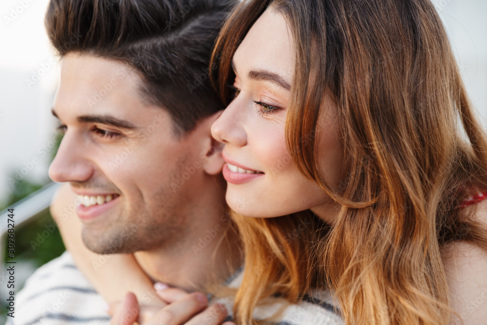 Image closeup of pleased beautiful couple smiling and hugging Image closeup of pleased beautiful couple smiling and hugging