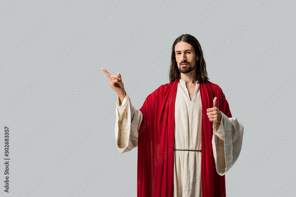 man in jesus robe showing thumb up and gesturing isolated on grey
