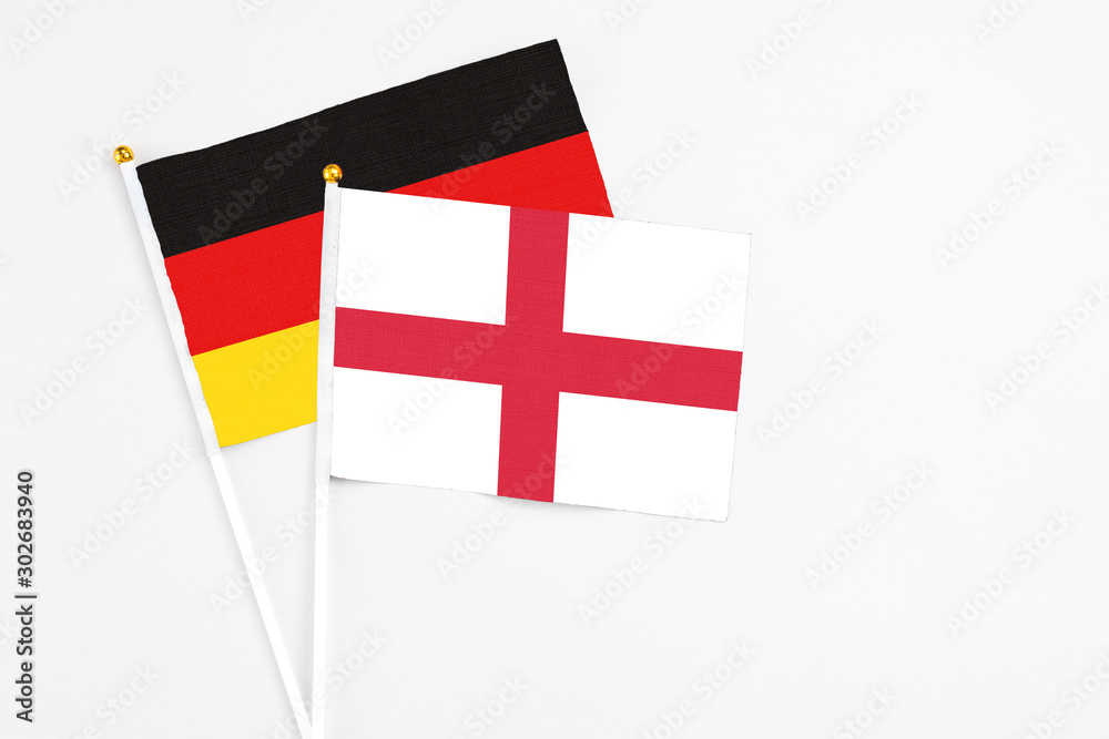 England and Germany stick flags on white background. High quality fabric, miniature national flag. Peaceful global concept.White floor for copy space.