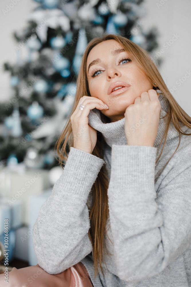 Portrait of young woman with christmas present boxes in front of christmas tree Portrait of young woman with christmas present boxes in front of christmas tree