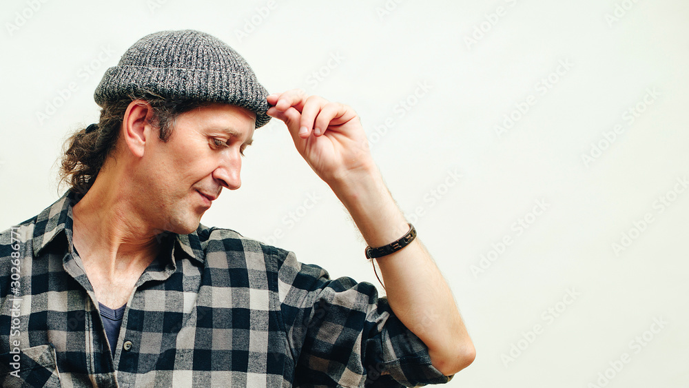Handsome hipster guy in plaid shirt and knitted hat over white background. People, lifestyle and hobby concept Handsome hipster guy in plaid shirt and knitted hat over white background. People, lifestyle and hobby concept