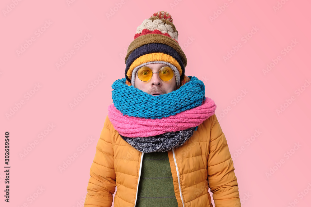 Handsome caucasian funny man in several hats and scarfs. - obrazy, fototapety, plakaty 