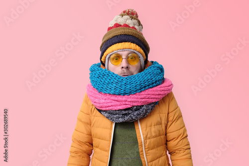 Handsome caucasian funny man in several hats and scarfs.