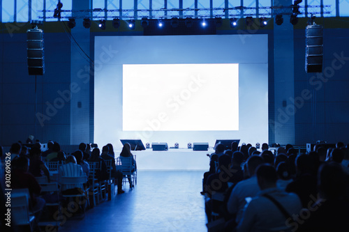 People are waiting for the speaker to speak, empty stage. Focus on the stage. blue toning photo photo