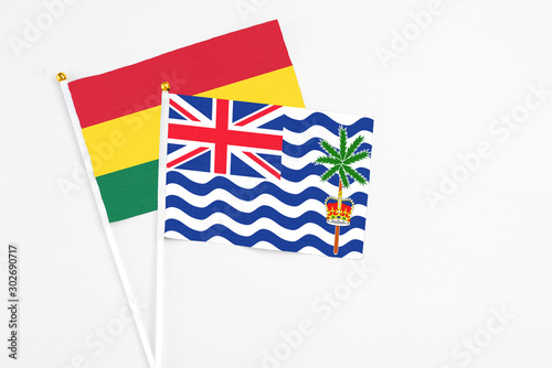 British Indian Ocean Territory and Ghana stick flags on white background. High quality fabric, miniature national flag. Peaceful global concept.White floor for copy space. photo