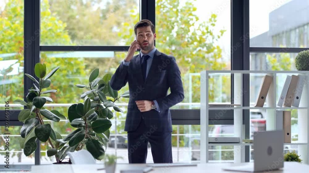 businessman talking on smartphone and walking in office businessman talking on smartphone and walking in office