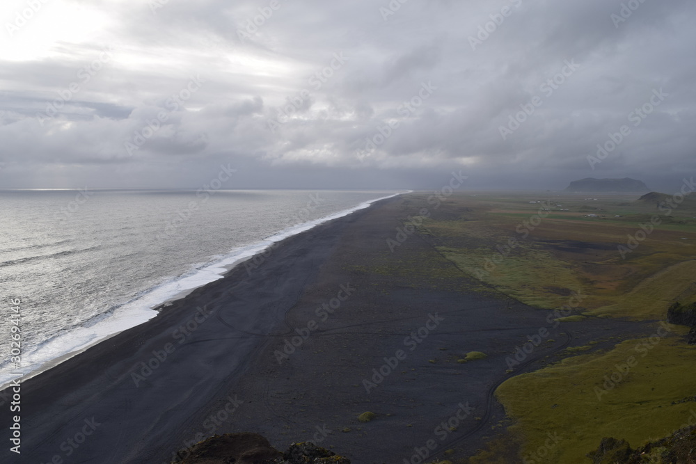 Black sand beach in southern Iceland on a cloudy day. Dramatic Icelandic landscape.