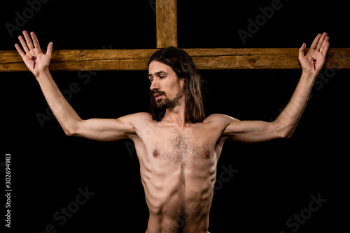 Canvas Print shirtless man crucified on wooden cross isolated on black