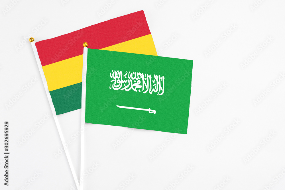 Fototapeta premium Saudi Arabia and Ghana stick flags on white background. High quality fabric, miniature national flag. Peaceful global concept.White floor for copy space.