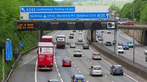 Moving Traffic on the famous M25 Motorway under Heathrow airport road sign.