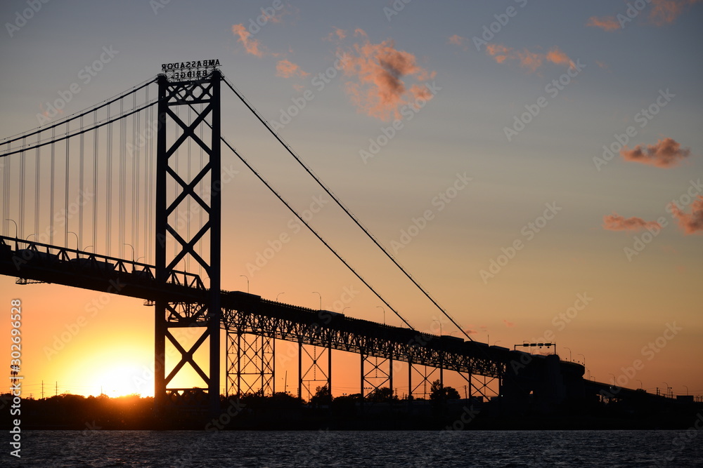 Fototapeta premium Ambassador Bridge between Detroit, Michigan and Windsor, Ontario. Sunset on the Detroit River with the silhouette of the bridge. Border crossing between the US and Canada