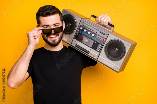 Close up photo of charming imposing guy hold boombox on his shoulder want listen music spring time trip touch modern spectacles wear black friday outfit isolated bright color background