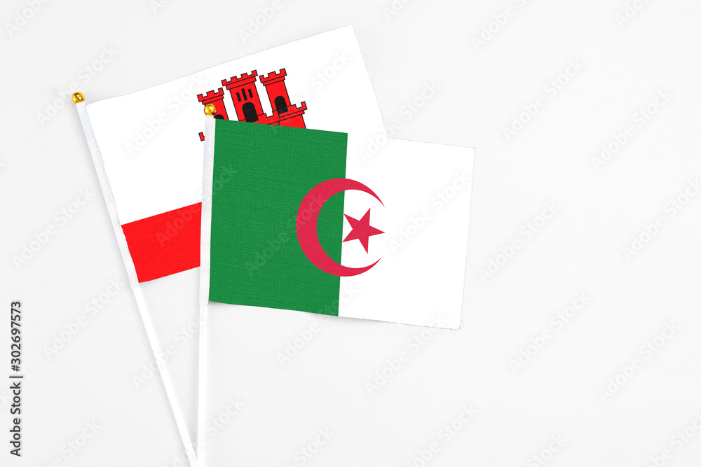 Algeria and Gibraltar stick flags on white background. High quality fabric, miniature national flag. Peaceful global concept.White floor for copy space. Algeria and Gibraltar stick flags on white background. High quality fabric, miniature national flag. Peaceful global concept.White floor for copy space.