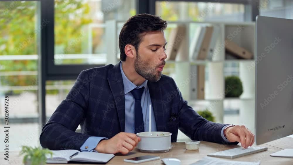 handsome businessman eating salad in office handsome businessman eating salad in office