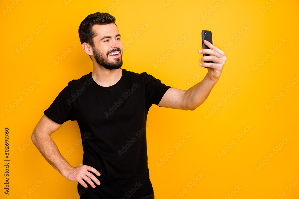 Portrait of positive cheerful guy have spring journey make selfie on his smartphone enjoy black friday wear good looking clothes isolated over yellow color background Portrait of positive cheerful guy have spring journey make selfie on his smartphone enjoy black friday wear good looking clothes isolated over yellow color background