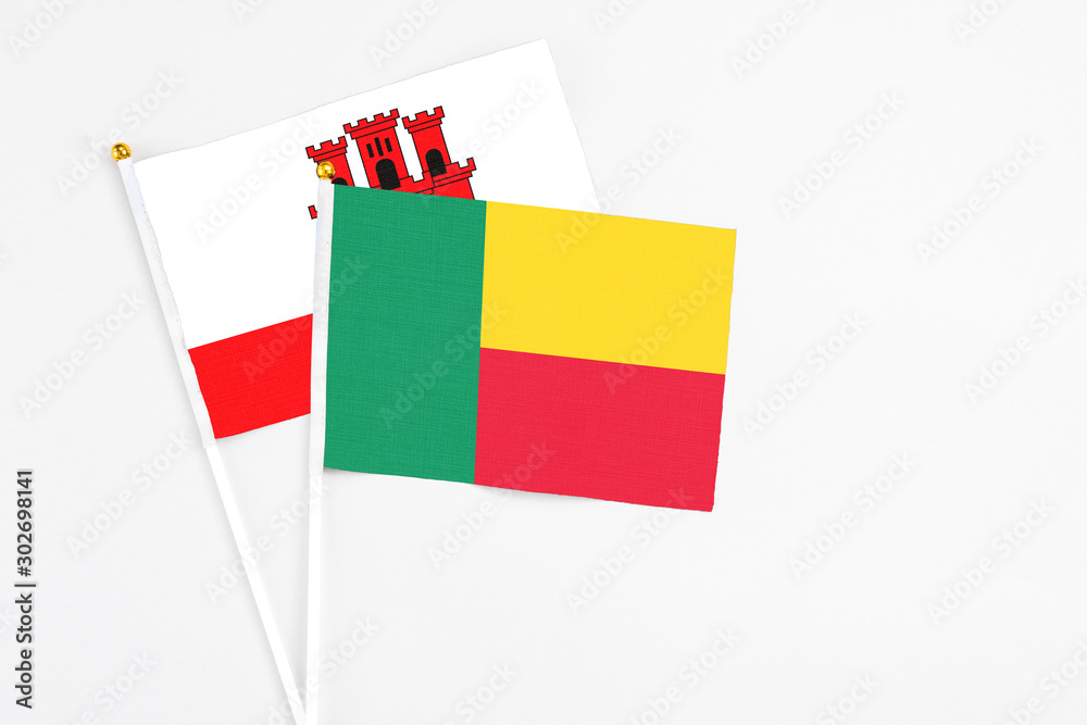 Benin and Gibraltar stick flags on white background. High quality fabric, miniature national flag. Peaceful global concept.White floor for copy space. Benin and Gibraltar stick flags on white background. High quality fabric, miniature national flag. Peaceful global concept.White floor for copy space.
