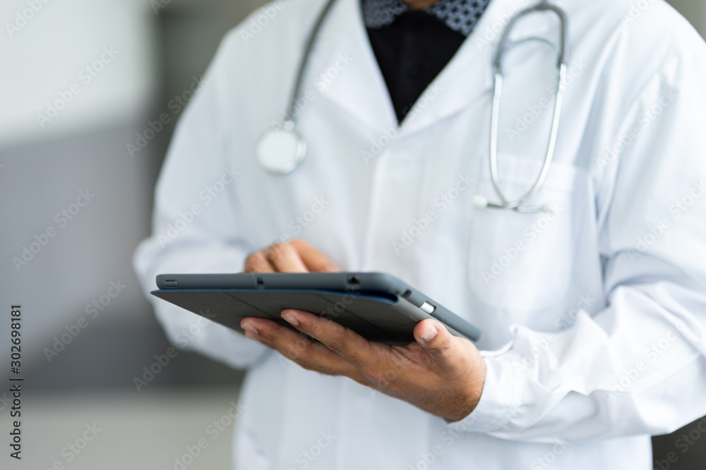 Close up of a doctor checking patient information via tablet. Close up of a doctor checking patient information via tablet.