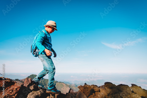 young boy with backpack travel in mountains, child hiking