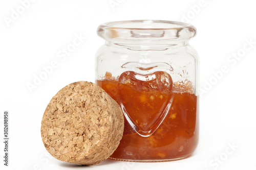 Glass jar opened with jam sauce and heart shape pattern white background