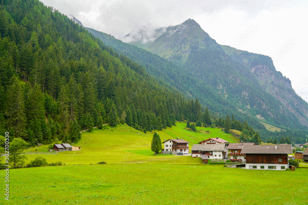 Alpine traditional landscape. lush green alpine meadows village high mountains