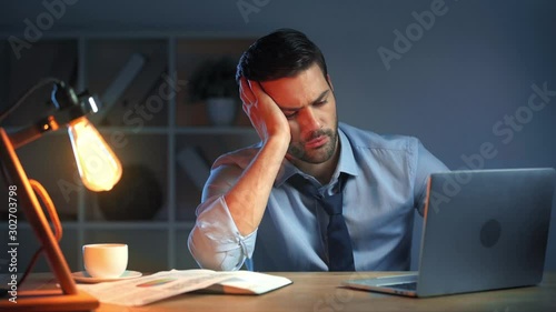 tired businessman using laptop in office  photo