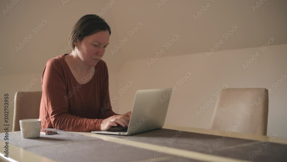 Woman typing laptop computer at home Woman typing laptop computer at home
