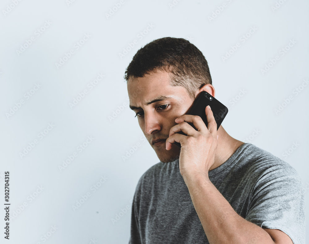 Hombre latino con seriedad recibiendo llamada Hombre latino con seriedad recibiendo llamada