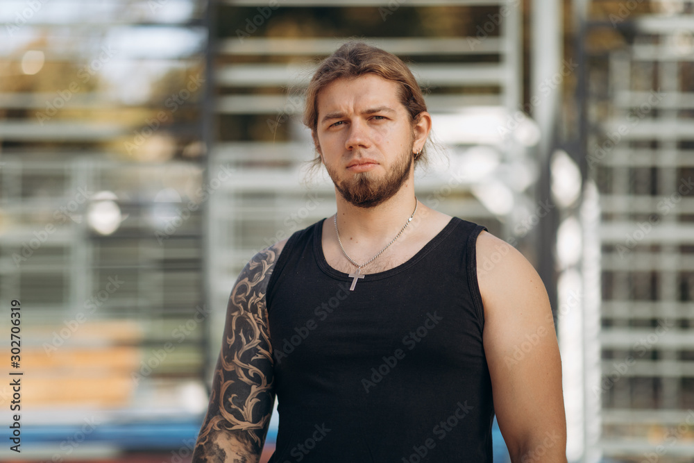 Young pretty man tired after weightlifting at gym. Attractive athlete resting after workout outdoors, fitness and healthy lifestyle concept Young pretty man tired after weightlifting at gym. Attractive athlete resting after workout outdoors, fitness and healthy lifestyle concept