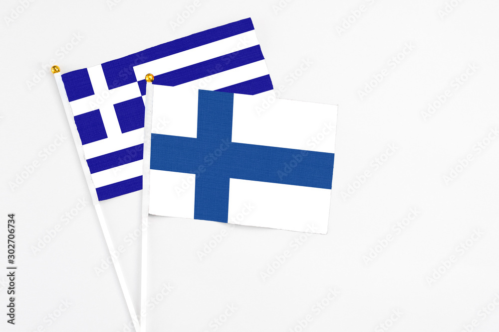 Finland and Greece stick flags on white background. High quality fabric, miniature national flag. Peaceful global concept.White floor for copy space.