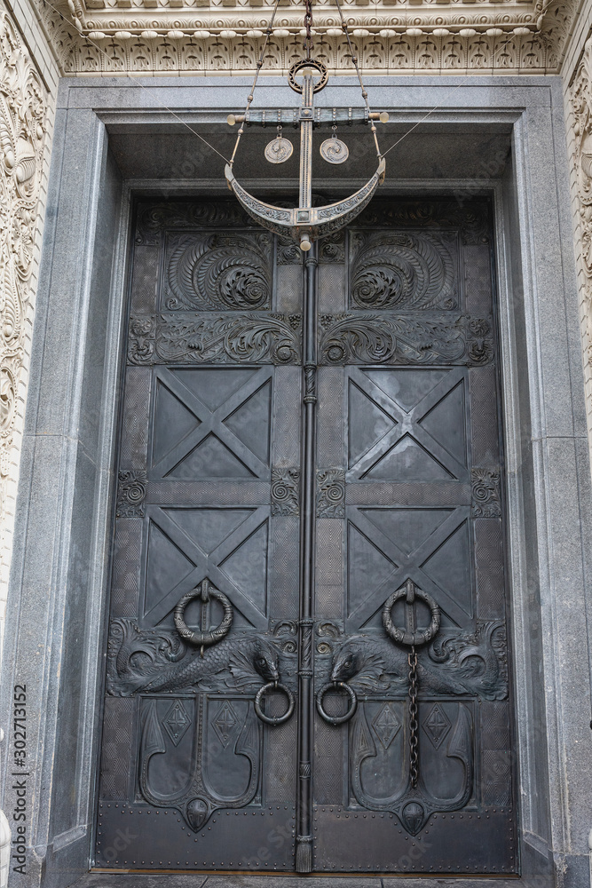A heavy metal door richly decorated with ornaments in the historical part of Kronstadt, Russia