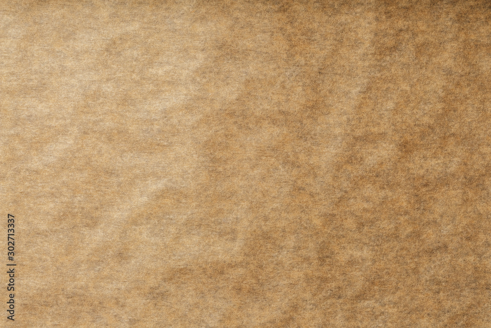 A roll of unfolded brown parchment paper, for baking food in on a dark background, top view. - obrazy, fototapety, plakaty 