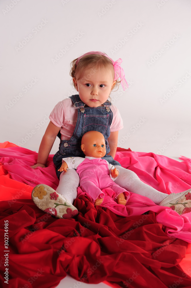 girl in the studio sitting on the floor with a doll girl in the studio sitting on the floor with a doll