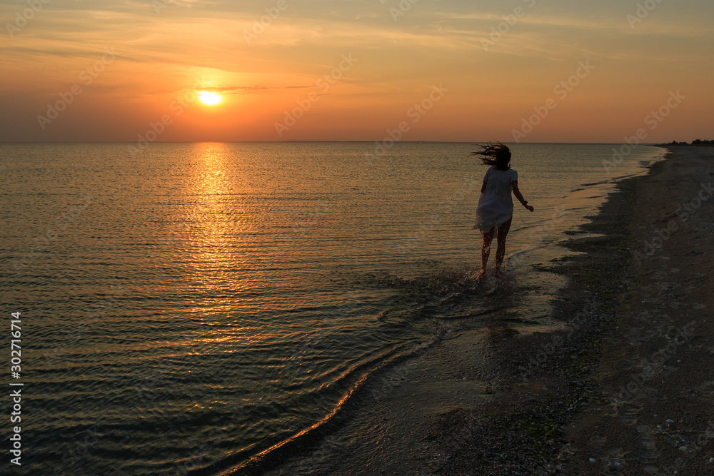 silhouette of a girl on the beach at sunset
