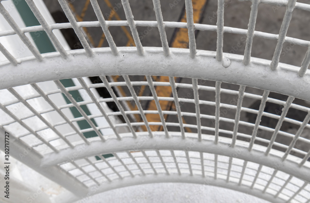 Metal railing. White rounded mesh fence. Close up and perspective view downwards. Texture background Metal railing. White rounded mesh fence. Close up and perspective view downwards. Texture background