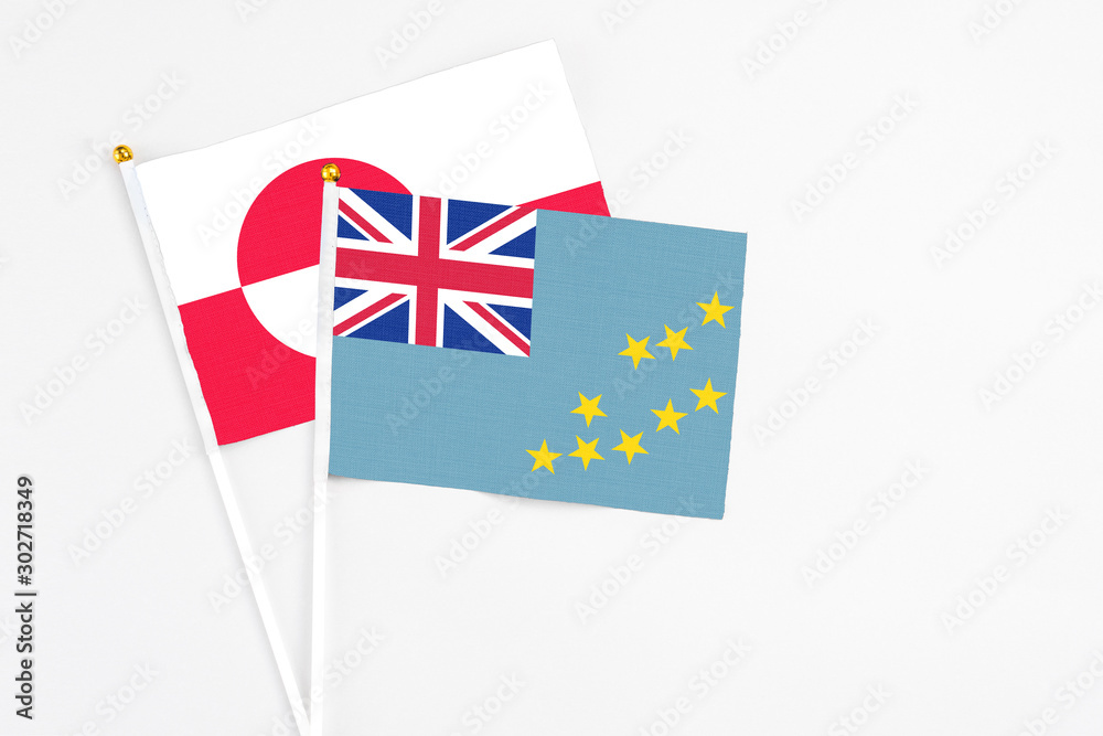 Fototapeta premium Tuvalu and Greenland stick flags on white background. High quality fabric, miniature national flag. Peaceful global concept.White floor for copy space.