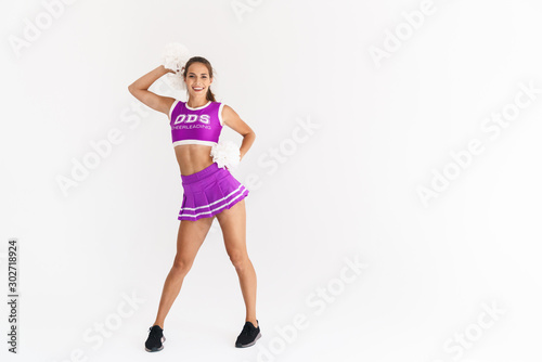 Portrait of smiling cheerleader woman dancing with pom-poms