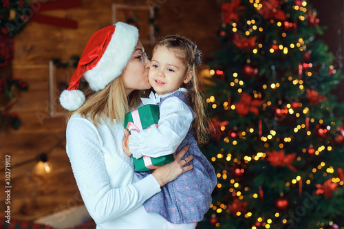 Mom with her daughter with gifts at Christmas. photo